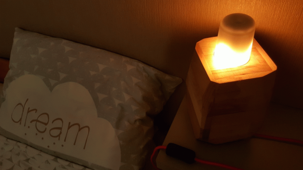 Lampe d'ambiance effet flamme réalisée en hêtre massif avec facettes taillées dans la masse.