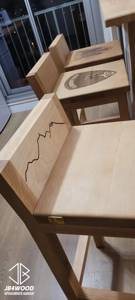 Gravures réalisées sur des tabourets de bar haut en bois massif de hêtre avec incrustation du numéro d'ouvrage dans une plaquette de laiton de 3mm ainsi que des gravures laser choisies par le client.