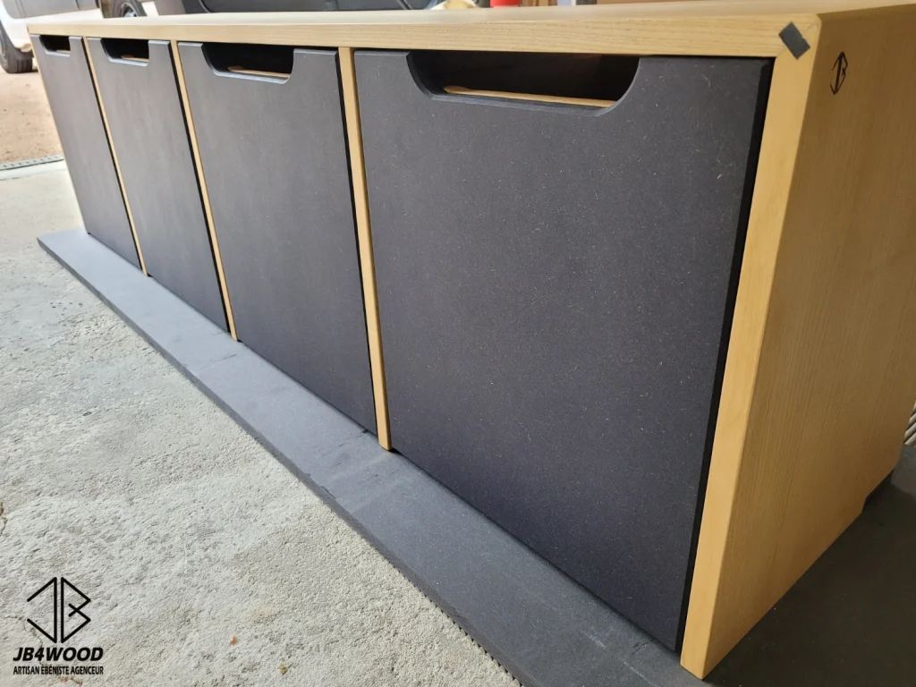 Banc en bois avec tiroirs intégrés, design des poignées conçu sur mesure. Assemblage du corps de meuble par rainure et languette dans coupe d'onglet, les façades de tiroirs sont en Valchromat usinés dans la masse.