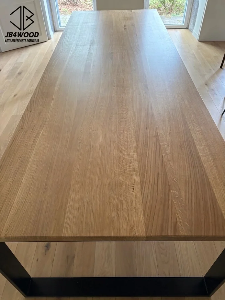 Table en chêne massif de 3 mètres de long avec ses 2 rallonges de 50cm chacune pour faire une tablée de 4 mètres de long pour les grands événements. Les pieds métallique est thermolaqué noir. J'ai conçu un système de rallonges tout à fait invisible tout en conservant l'esthétique du piètement voulu par les clients. Il y a un vernis transparent mat/satiné qui donne un super rendu naturel et surtout une superbe protection.